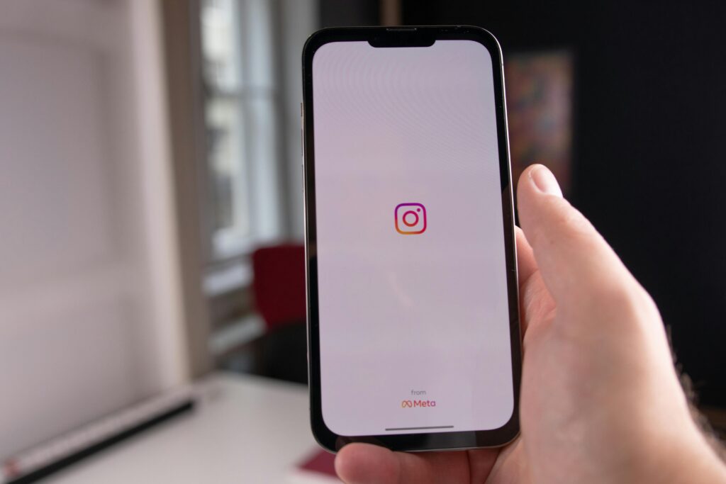 Co to barter – smartfon z aplikacją Instagram symbolizujący wymianę usług lub produktów bez użycia pieniędzy, często stosowaną w marketingu influencerów.